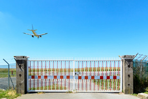 Airplane flying over a closed gate